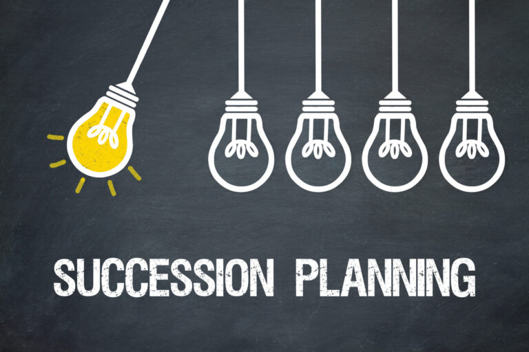 Illustration of five hanging light bulbs against a chalkboard background. The leftmost bulb is lit, symbolizing a bright idea or leadership. Text below reads Recruiting and Succession Planning in white chalk-like font.